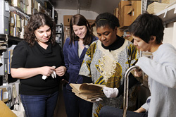 A group examining archival materials.