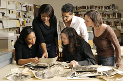 A group of Mapping The Stacks staff
examining materials from an archive.